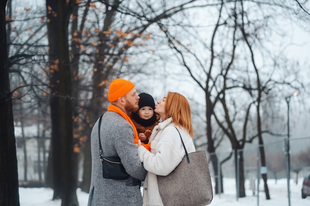 Pai mãe e bebê no parque no inverno