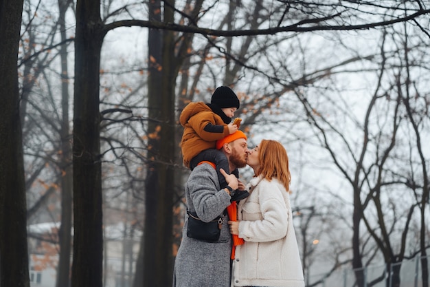 Pai mãe e bebê no parque no inverno