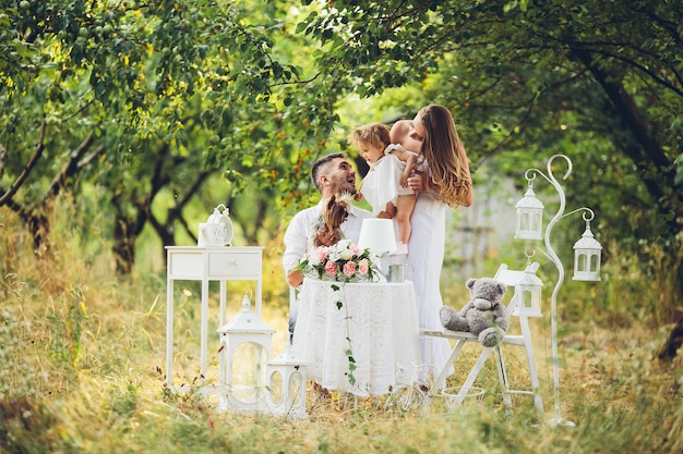 Pai, mãe e filha juntos no piquenique no jardim