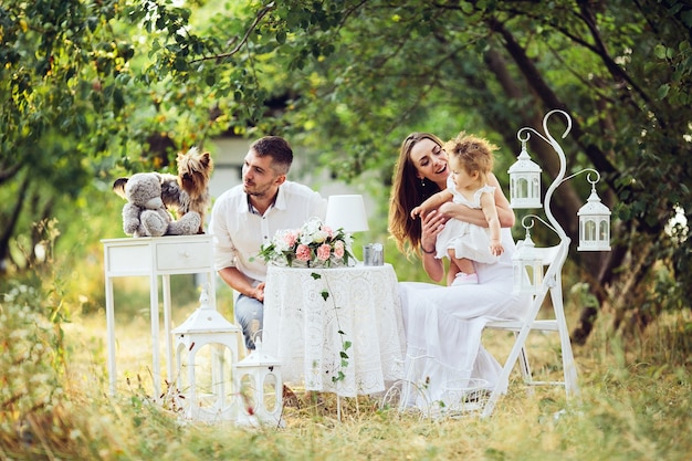 Pai, mãe e filha juntos no piquenique no jardim