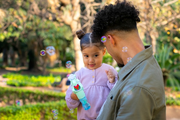 Foto grátis pai passando tempo com sua filha ao ar livre no dia dos pais