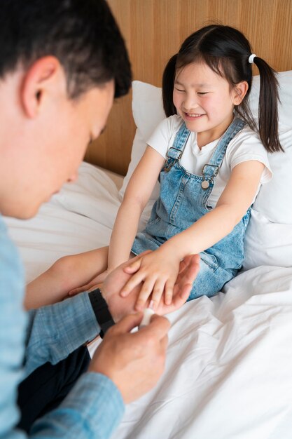 Pai pintando unhas de menina de perto