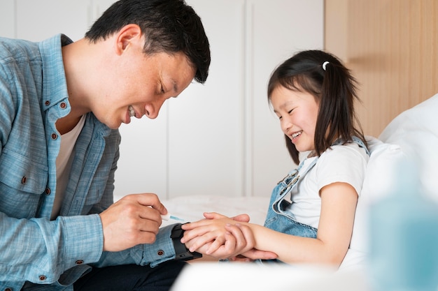 Pai pintando unhas de menina tiro médio