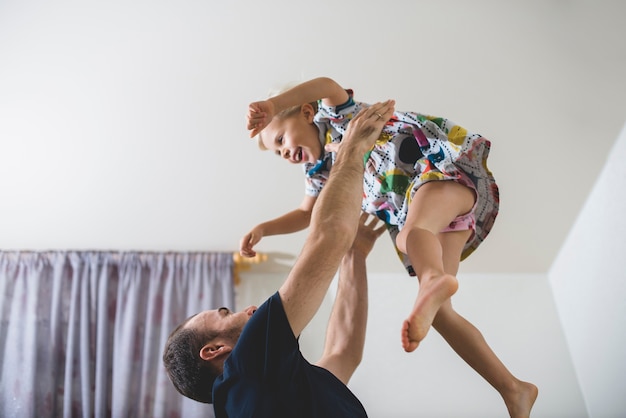 Pai que joga com sua filha feliz