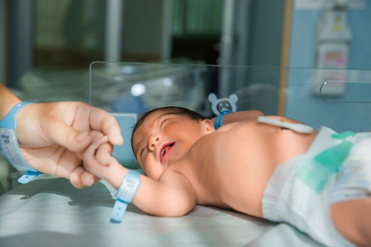 Foto grátis pai segura a mão do bebê recém-nascido em fraldas