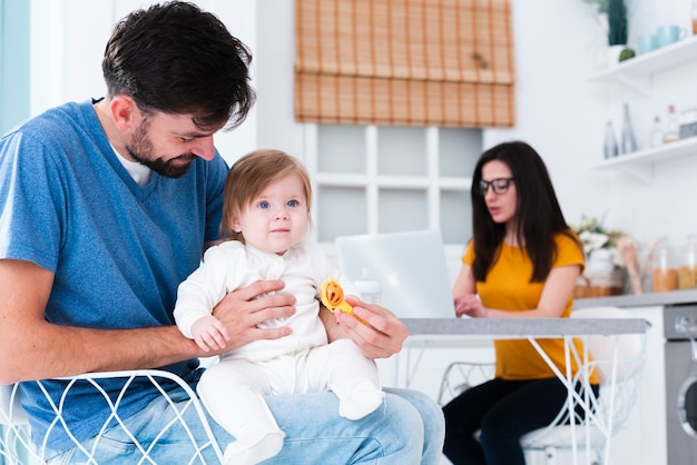 Pai, segurando o filho na cozinha