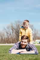 Foto grátis pai sorridente barbudo encontra-se com o filho pequeno no parque.