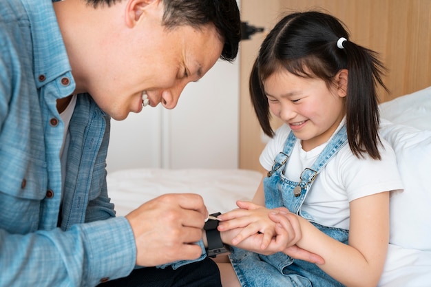 Pai sorridente pintando unhas de menina