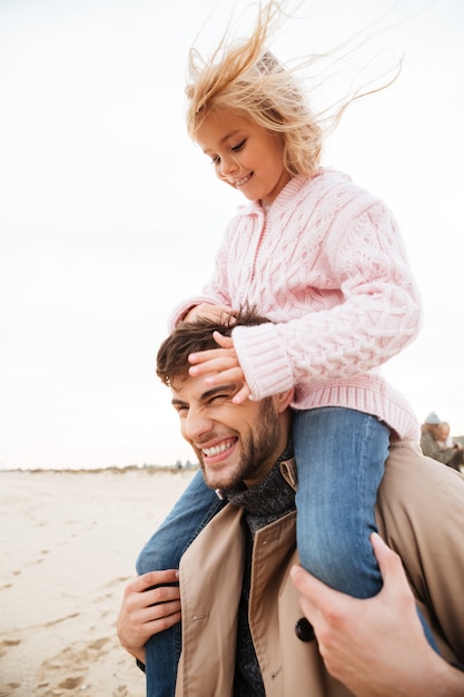 Pai sorridente se divertindo com sua filha pequena