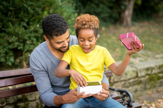 Pai surpreendendo sua filha com um novo telefone celular