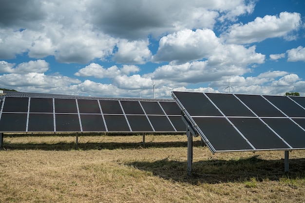 Painéis solares no campo de grãos no campo sob céu nublado