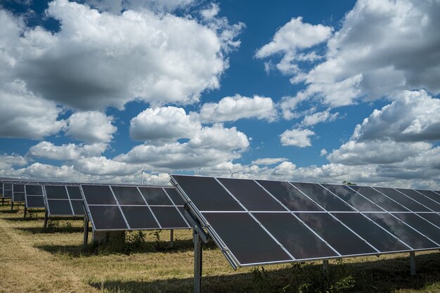 Painéis solares usados para energia renovável no campo sob o céu cheio de nuvens