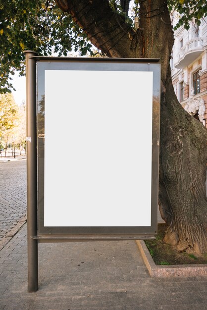 Painel publicitário perto da árvore