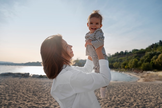 Pais com um bebê na praia ao pôr do sol