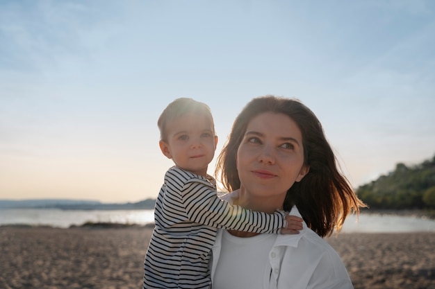 Pais com um bebê na praia ao pôr do sol