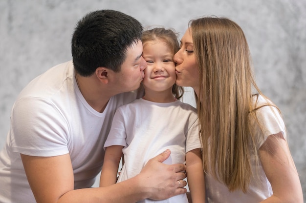 Foto grátis pais de baixo ângulo beijando menina