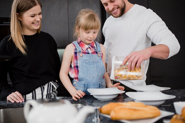 Pais e filha cozinhar café da manhã