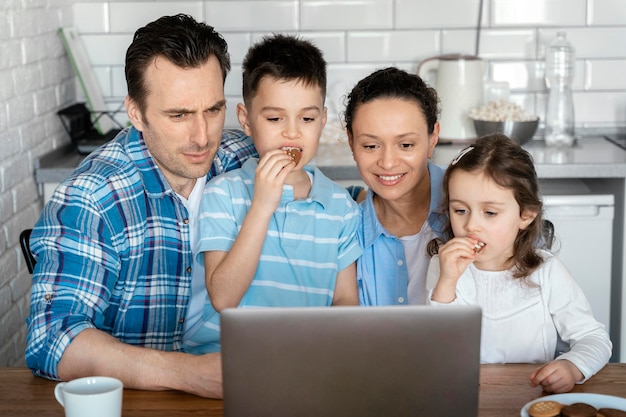 Foto grátis pais e filhos em planos médios com laptop