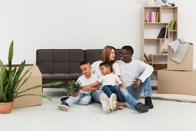 Pais e filhos ficando juntos no chão em casa