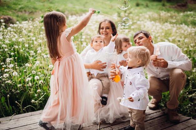 Foto grátis pais e seus filhos brincam com balões de sabão