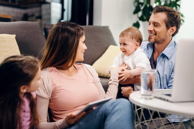 Pais felizes desfrutando com sua filha e bebê em casa