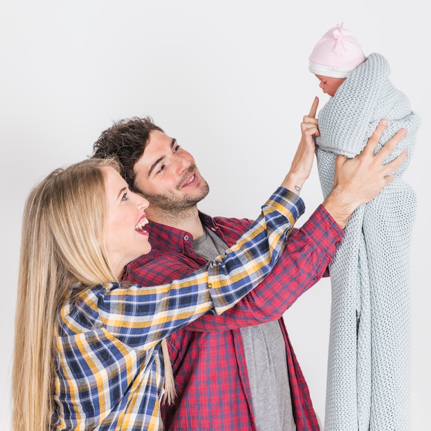 Pais felizes, olhando para o bebê nas mãos