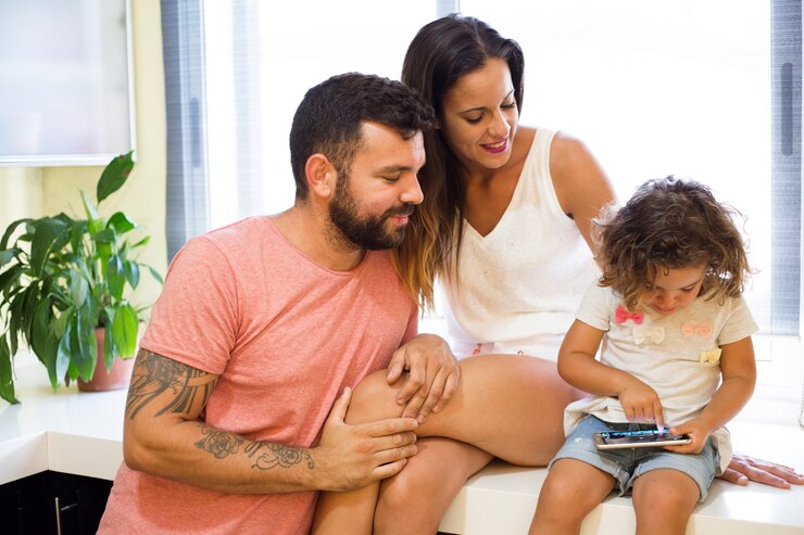 Foto grátis pais, olhar, seu, filha, jogo jogando, em, smartphone