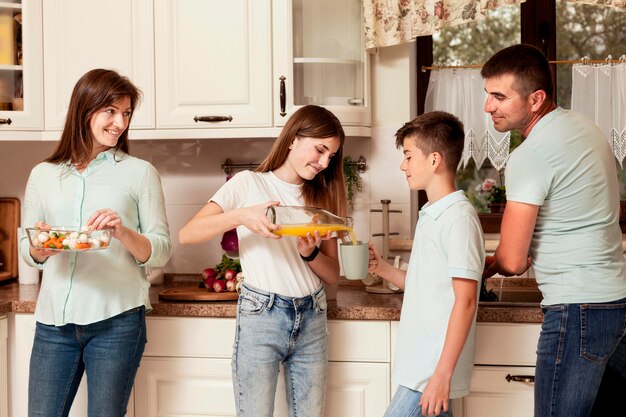 Pais preparando comida com crianças na cozinha