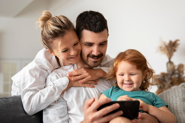 Pais sorridente e criança com telefone