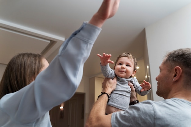 Pais sorridentes e criança fofa dentro de casa