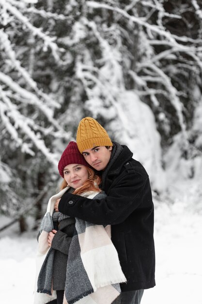 Paisagem congelada de inverno com casal abraçando