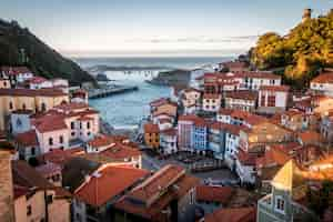 Foto grátis paisagem de cudillero cercada por colinas e mar sob a luz do sol na espanha