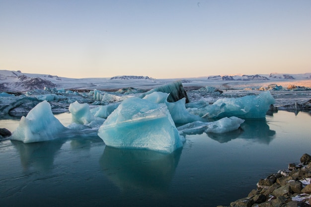 Paisagem de icebergs com rochas na lagoa glaciar de Jökulsarlon, na Islândia