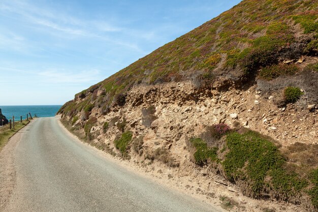 Paisagem de uma estrada de montanha com mar e céu azuis