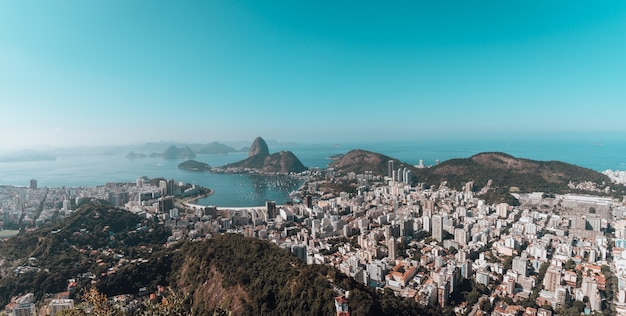 Paisagem do Rio de Janeiro cercada pelo mar sob um céu azul no Brasil