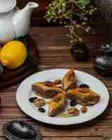 Foto grátis pakhlava azerbaijano da sobremesa com porcas e sultana dentro da placa branca.