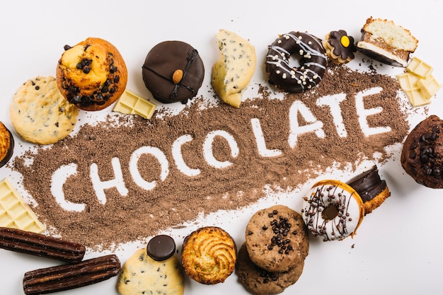 Foto grátis palavra chocolate em gotas de chocolate entre doces