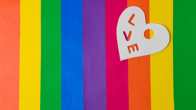 Foto grátis palavra de amor no coração sobre brilhante bandeira lgbt