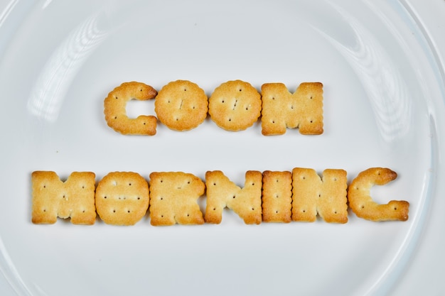 Foto grátis palavra de bom dia escrita com biscoitos em um prato branco.