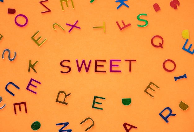 Foto grátis palavra doce soletrada com fundo de alfabetos