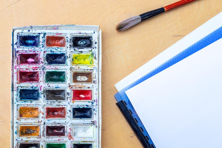 Foto grátis paleta com aquarelas uma paleta com acuarelas e pincel