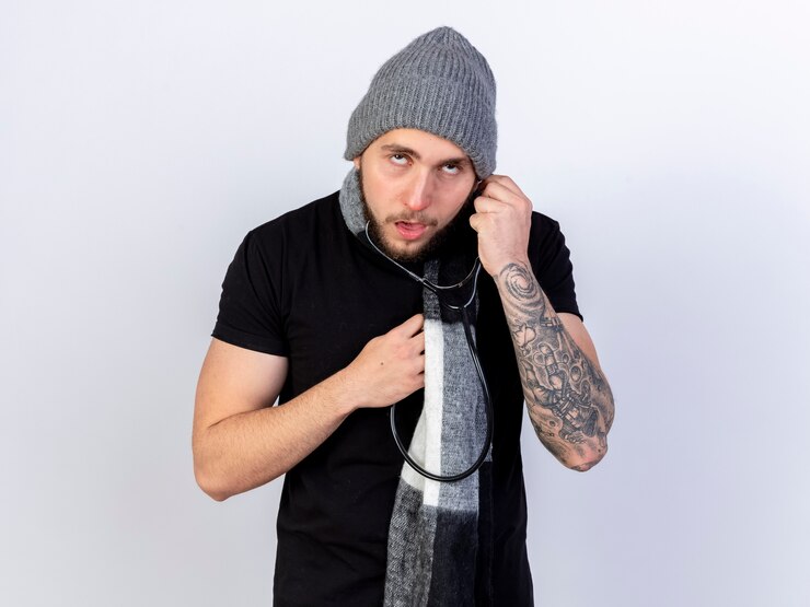 Foto grátis pálido, jovem, caucasiano, doente, usando chapéu e lenço de inverno segurando um estetoscópio isolado na parede branca com espaço de cópia