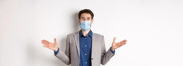 Pandemia de saúde e conceito de negócios confuso empresário em máscara médica e terno espalhado lado das mãos