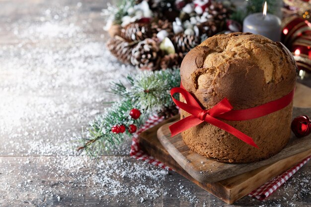 Panetone de Natal tradicional e enfeite de Natal na mesa de madeira