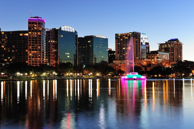 Panorama do horizonte do centro de Orlando sobre o Lago Eola ao entardecer com arranha-céus urbanos e céu claro.