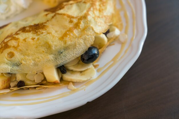 Panqueca e frutas com gelado na tabela.