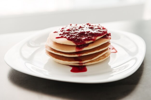 Panquecas com geléia na cozinha em casa.