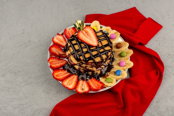 Foto grátis panquecas de vista superior com frutas frescas e chocolate no chão cinza