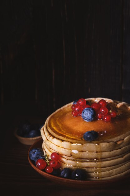 Panquecas doces de mirtilo e cobertura de groselha. Panquecas caseiras com frutas vermelhas e flocos de coco