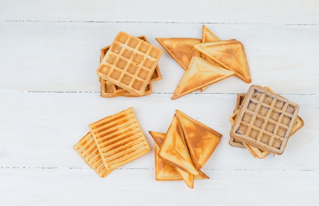 Panquecas e waffles em uma superfície de madeira branca